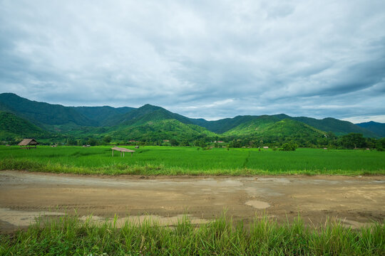 Side view of gravel road in countryside and Beautiful natural panoramic countryside landscape with mountains.