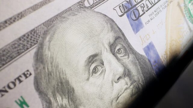 US dollar banknotes counted by automatic machine before currency exchange. Foreign exchange, international finance, travel money, exchange office and global business concept
