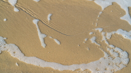 Abstract pattern of foam and sand on the shoreline, Australia © The Long Horizon