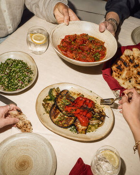 People sharing colorful Mediterranean dishes at dinner