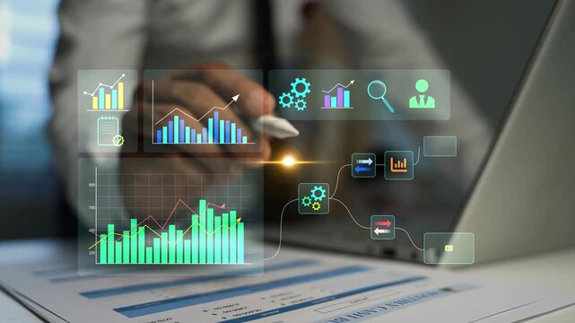 Businessman touching holographic digital charts and data icons over financial reports and laptop, Business data analysis, planning, growth and modern office work 