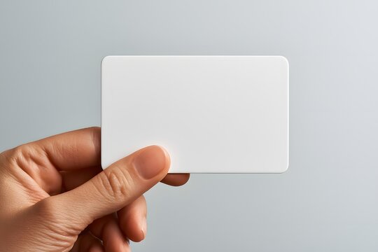 close up of a blank membership card held confidently in front of a neutral background, customer loyalty program, branding mockup, clean minimalist commercial stock photography