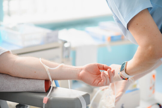 Person donating blood in medical clinic for transfusion