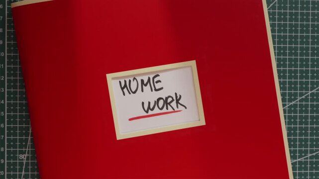 Red Home Work workbook folder on wooden desk background
