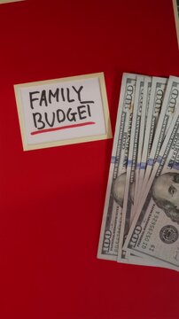 Family Budget red notebook with US dollar bills flat lay