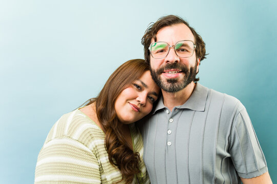 Smiling couple showing affection and happiness, woman resting head on man's shoulder, embracing love in relationship