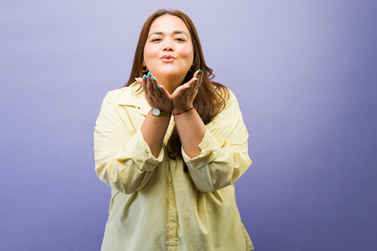 Attractive confident woman blowing a kiss, expressing positive emotions and happiness