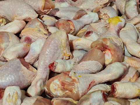 Fresh raw chicken legs piled together showcasing skin, flesh, and natural textures for culinary use. Ideal for food preparation, restaurant marketing or grocery store displays highlighting poultry.