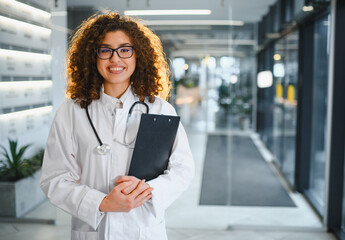 Empowering female doctor smiling in modern healthcare clinic