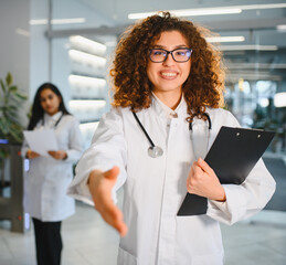 Female doctor extending hand offering handshake greeting © Serhii