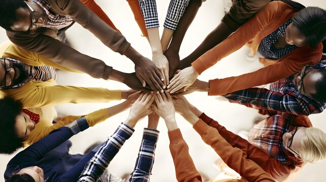 Diverse business team joining hands in circle, overhead view of multiethnic group unity, professional collaboration and teamwork concept