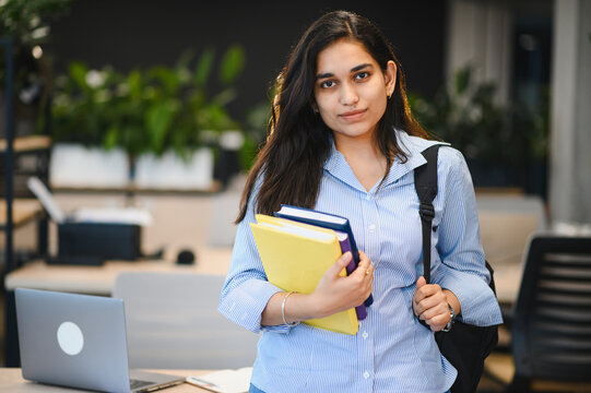 Young indian student carrying books and backpack for study