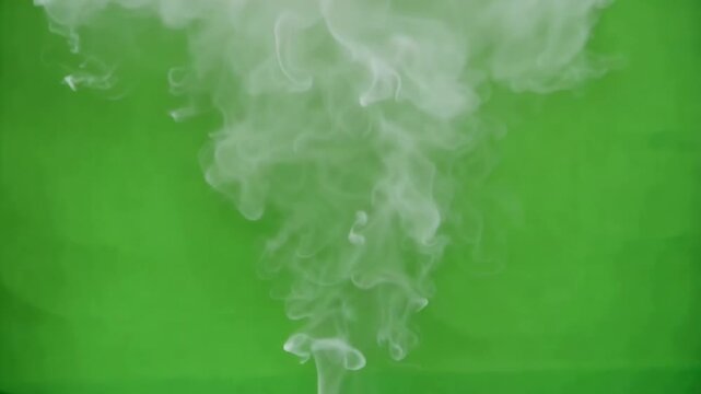 White smoke rising against a vibrant green screen background with cinematic motion