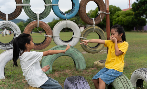 Happy children laughing while playing rock paper scissors on an outdoor playground. Genuine childhood emotions, friendship, fun competition, communication, teamwork and joyful recreation in nature.