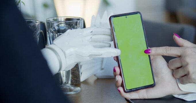 Prosthetic Arm Using a Smartphone on a Caf&eacute; Table in a Modern Lifestyle Setting