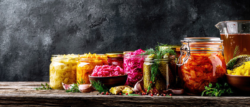 Assorted Fermented Vegetables and Pickled Foods in Glass Jars. AI generative.