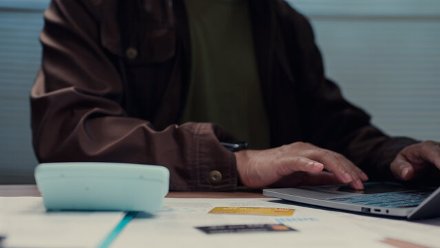 Person typing keyboard calculating budget checking credit card document desk workspace finance accounting banking payment loan economy corporate strategy market profit revenue cost expense task job.