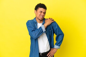 Fototapeta premium Young African American man isolated on yellow background suffering from pain in shoulder for having made an effort