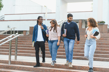 Obraz premium Diverse students walking down campus stairs together