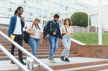 Obraz premium Diverse students walking down university stairs outdoors