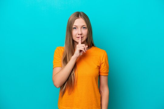 Young Russian woman isolated on blue background showing a sign of silence gesture putting finger in mouth