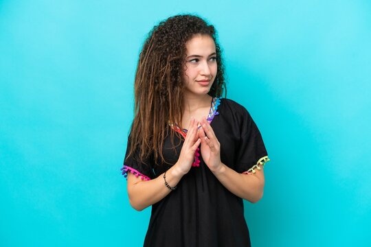 Young Arab woman isolated on blue background scheming something