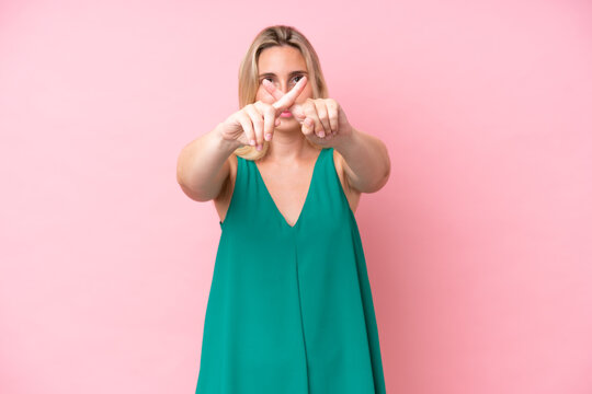 Young caucasian woman isolated on pink background making stop gesture with her hand to stop an act