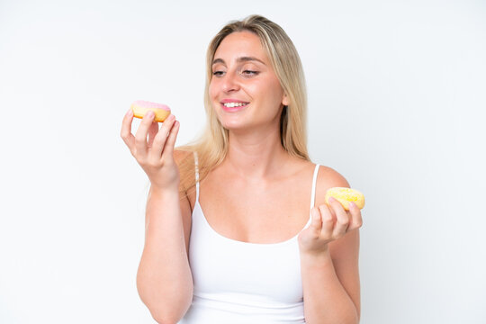 Young caucasian woman isolated on white background holding donuts with happy expression