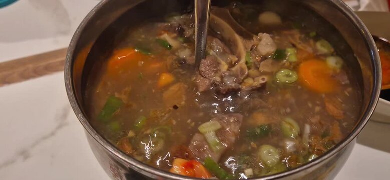 cooking pot with oxtail soup and vegetables