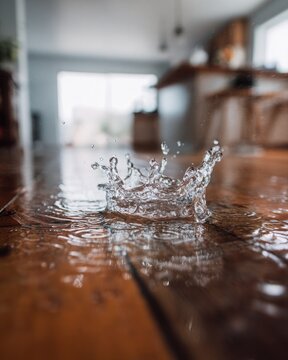 Closeup of Water Splash Droplet on Wooden Floor Surface
