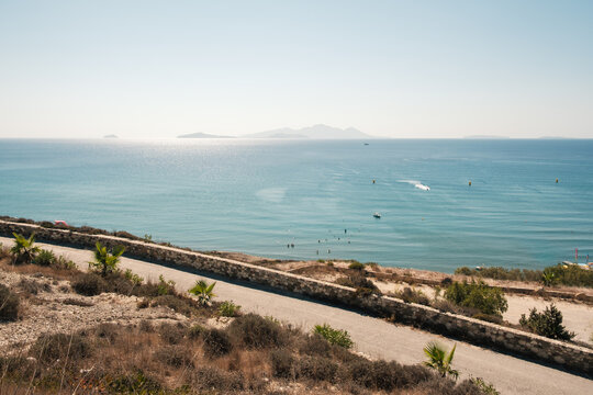 Sunny day at beach on the Greek island of Kos, with mountains in the background.