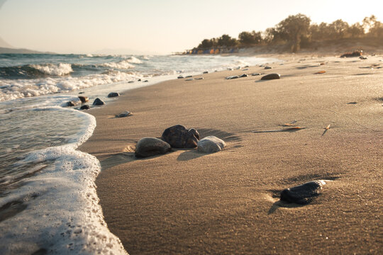 A view of a wave breaking on rocks on a beach in Greece.