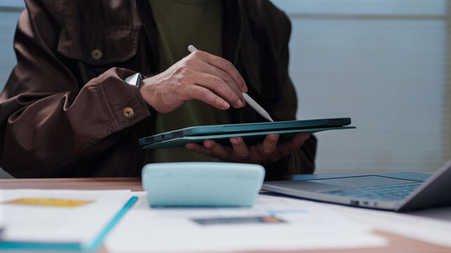 Man holding tablet calculating budget accountant checking tax forms manager reviewing finance report strategy planning market analysis business operations workspace desk computing digital tech data.
