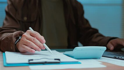 Person sitting workspace reviewing monetary documents' clipboard calculating budget corporate...