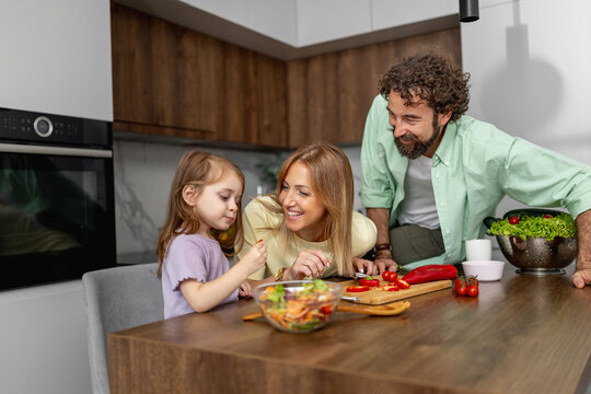 Family cooks together in modern kitchen with fresh vegetables