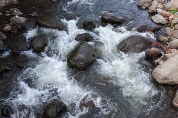 Fast flowing river water rushing over rocks in a stream © zetiawan aginc