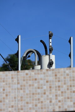 Electric fence security system with metal posts and wires against a clear blue sky