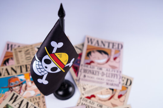 Riau, August 1, 2026, Close-up of One Piece pirate flag with Straw Hat crew wanted posters in the background. Ideal anime-themed visual for fans, collectors, or creative editorial use