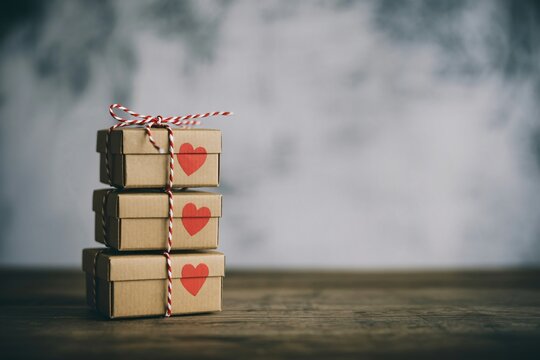 Stack of Wrapped Gift Boxes with Heart Tags Rustic Romantic Background