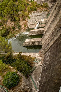 Massive concrete wall at Beniarres Dam with water flowing into the Serpis River in Alicante, Spain