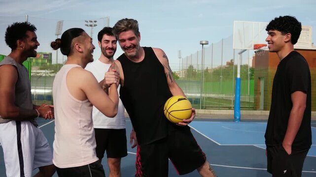 Group of multiethnic basketball players giving high five to each other on an outdoor court