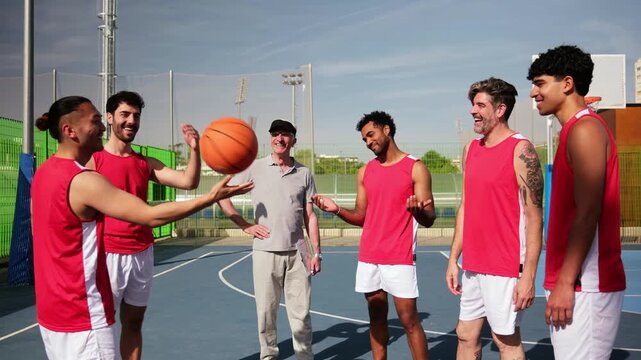Young player shows off spinning a basketball on his finger for his coach and teammates on a court