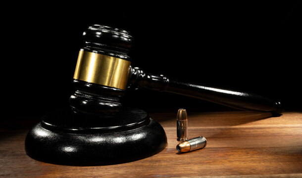 Judge's gavel with two pistol rounds on the table