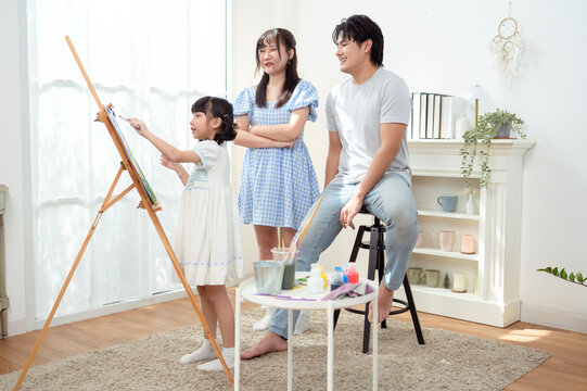 Girl Paints With Family in Home as They Enjoy Creative Education Time Together
