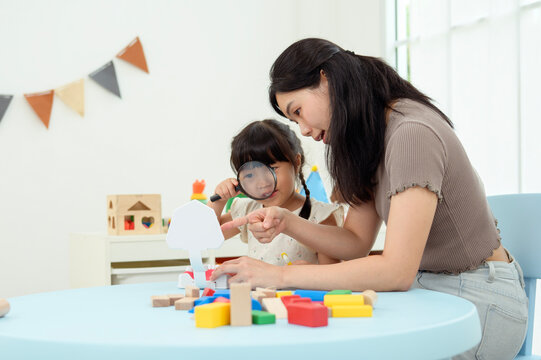 Girl and Mom Work Together on a Fun Activity at Home While Learning to Brush Teeth