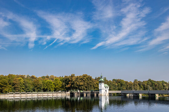 Lake dam with tower and trees under blue sky, Germany, Bavaria, Kuhsee, Augsburg, 2 August 2026
