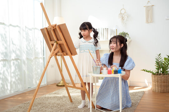 Girl Learns Painting With Mom in a Bright Room During the Afternoon Hours