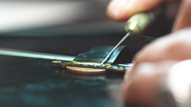 Technician repairing a laptop connector with precision tools close up detail workbench