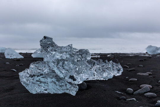 Diamond Beach Jokulsarlon transparent ice block on black sand in Iceland