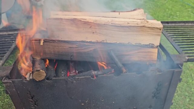 Enjoying a fire with burning logs in a backyard setting during evening hours
